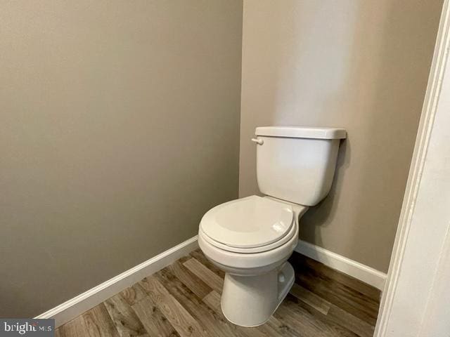 bathroom with hardwood / wood-style floors and toilet