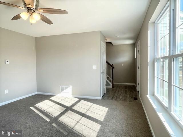 spare room featuring dark carpet