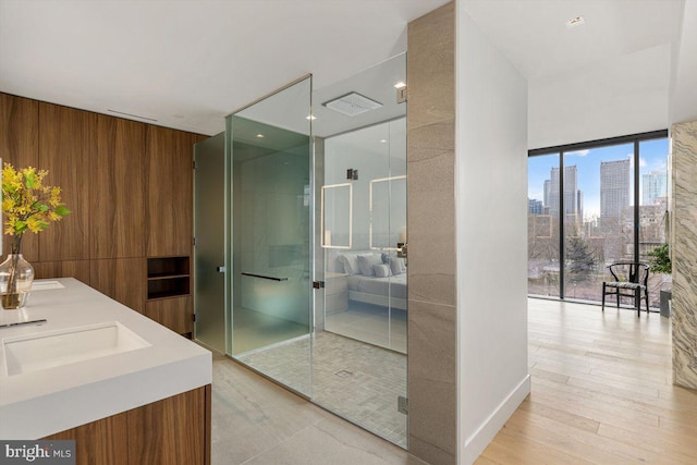 bathroom featuring vanity, a shower with shower door, and expansive windows