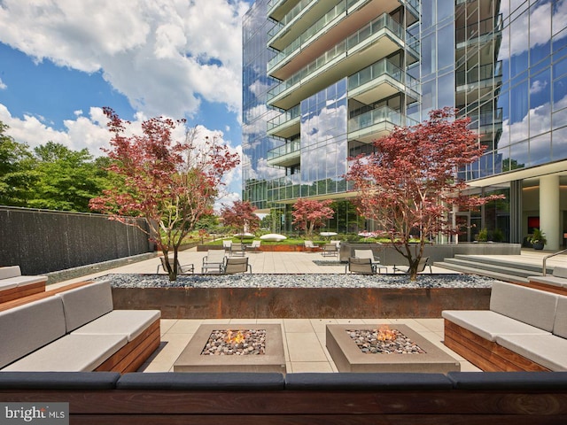 view of property's community featuring an outdoor living space with a fire pit and a patio