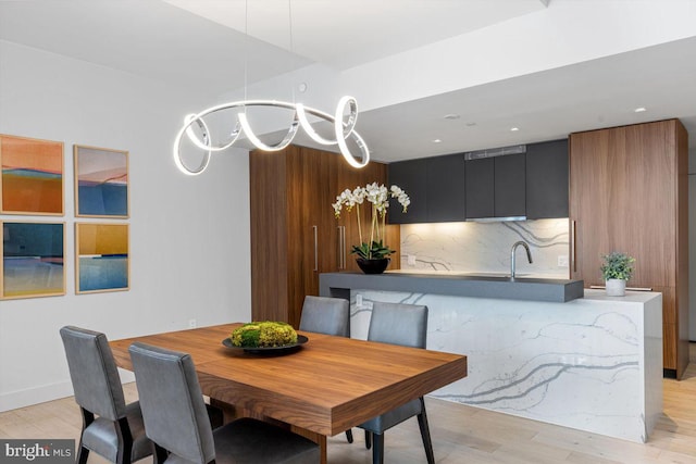 dining room featuring sink and light hardwood / wood-style flooring