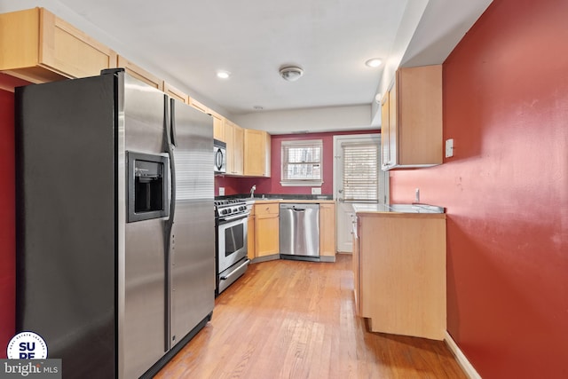 kitchen with light wood-type flooring, stainless steel appliances, light brown cabinetry, and sink