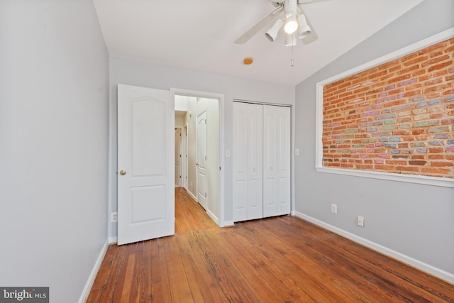 unfurnished bedroom featuring hardwood / wood-style floors, a closet, and ceiling fan