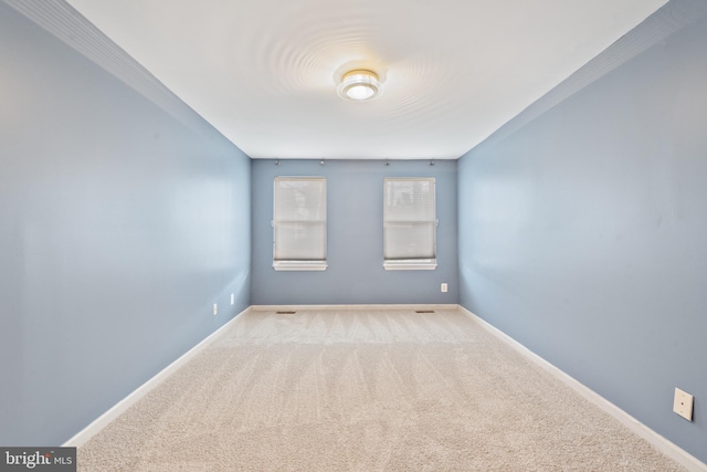 spare room featuring light carpet