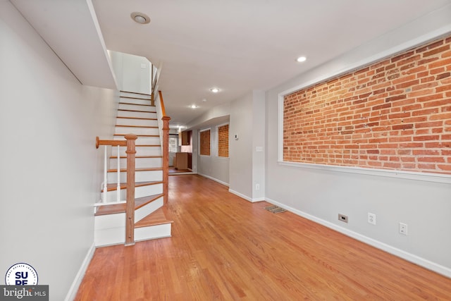 interior space featuring light hardwood / wood-style flooring and brick wall