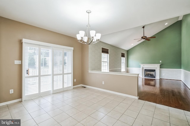 kitchen with light tile patterned flooring, vaulted ceiling, pendant lighting, and ceiling fan with notable chandelier