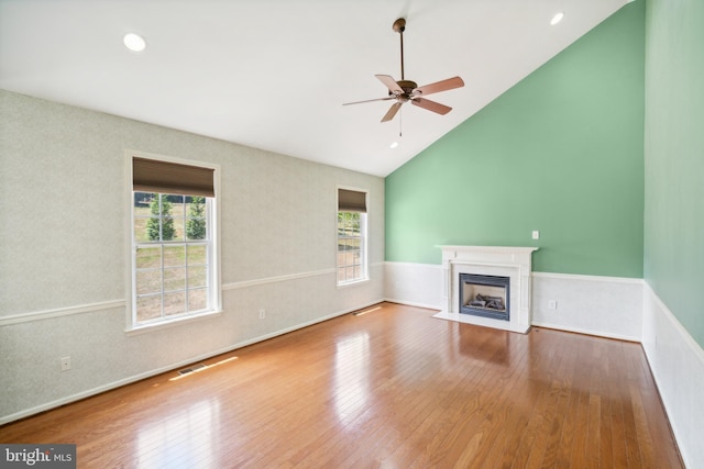 unfurnished living room featuring hardwood / wood-style floors, vaulted ceiling, and ceiling fan