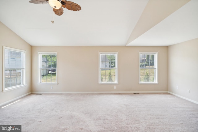 spare room featuring light carpet, plenty of natural light, and vaulted ceiling