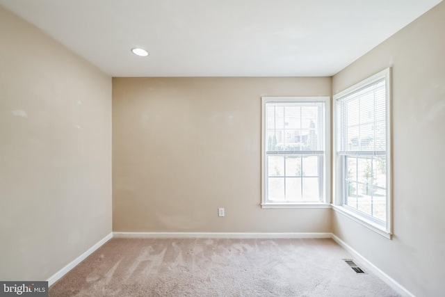 spare room featuring light colored carpet