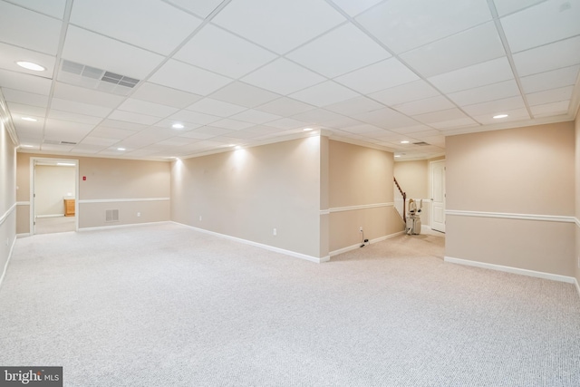 basement featuring light colored carpet and a drop ceiling