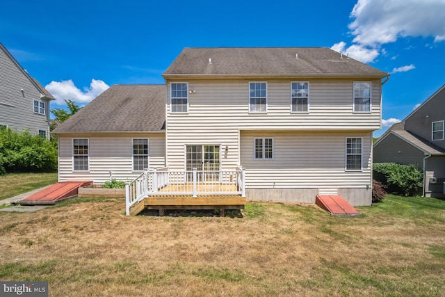 back of property with a yard and a wooden deck