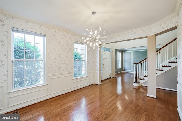 entryway featuring crown molding, an inviting chandelier, and hardwood / wood-style floors