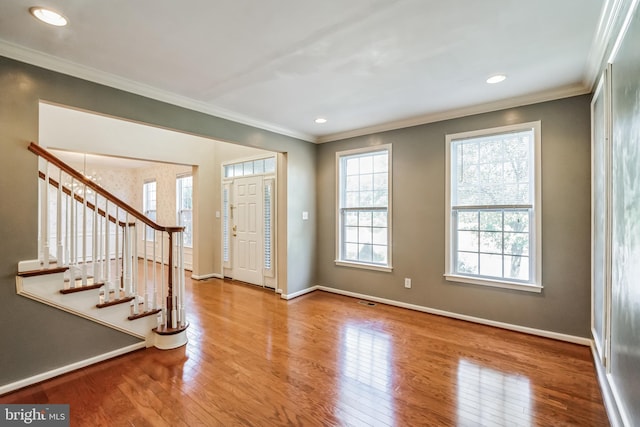 entrance foyer with ornamental molding and hardwood / wood-style floors