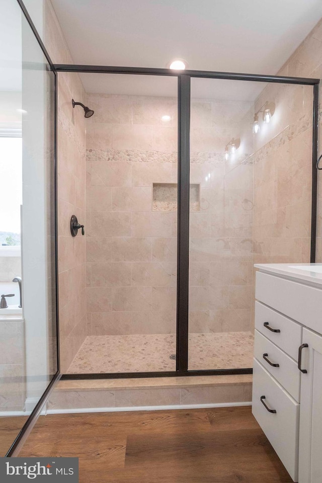 bathroom featuring a stall shower, wood finished floors, and vanity