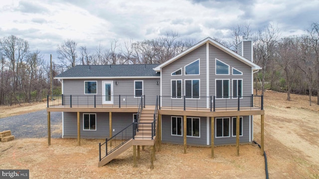 back of house with a deck, a chimney, and stairs