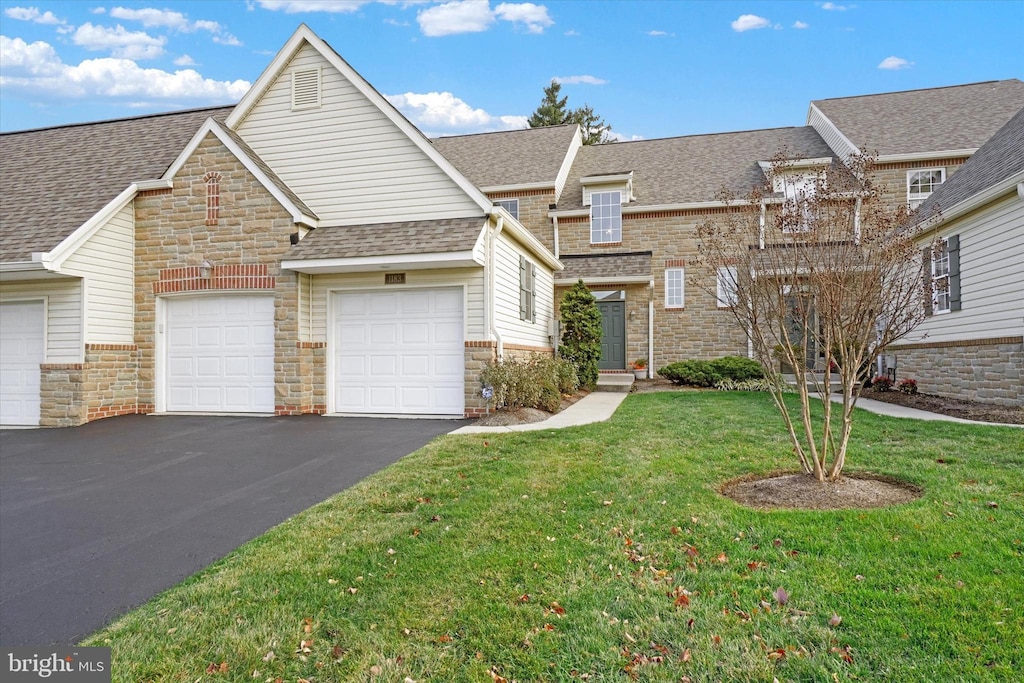 view of front of home with a garage and a front lawn