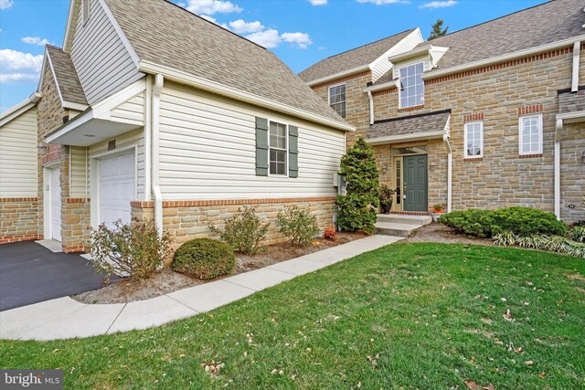 view of front of home with a front lawn and a garage