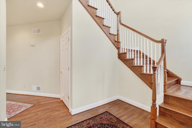 stairs featuring hardwood / wood-style floors