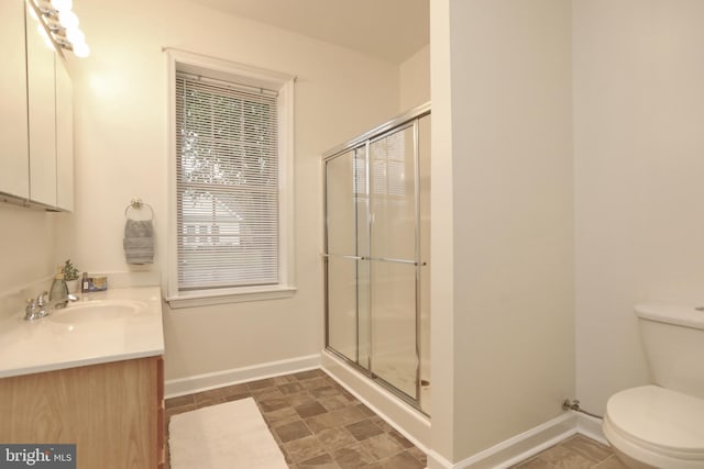 bathroom with toilet, vanity, and walk in shower