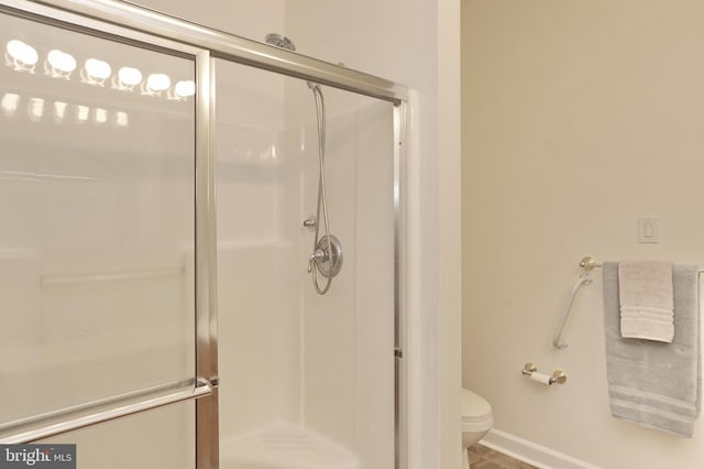 bathroom featuring toilet and an enclosed shower