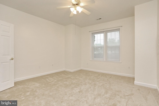 empty room featuring ceiling fan and light colored carpet