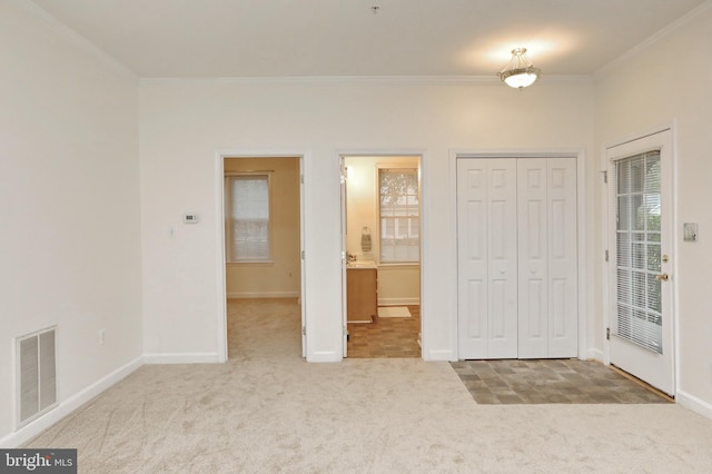 unfurnished bedroom with connected bathroom, crown molding, and carpet flooring