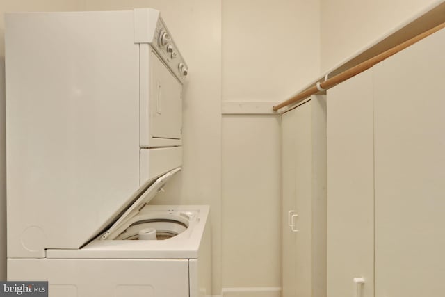 washroom featuring stacked washer / drying machine