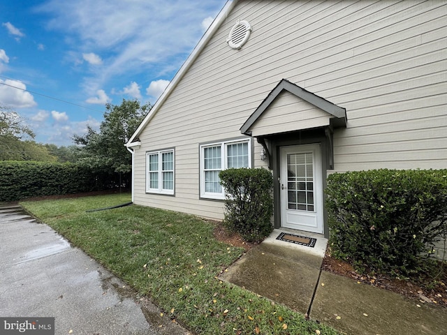 view of exterior entry with a lawn