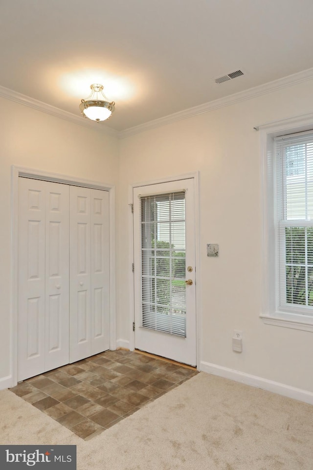 carpeted foyer with ornamental molding