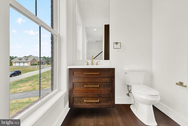 bathroom with hardwood / wood-style flooring, vanity, and toilet