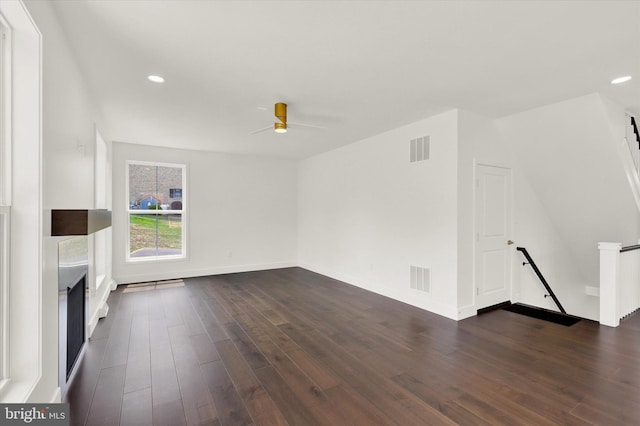 unfurnished living room with dark hardwood / wood-style flooring and ceiling fan