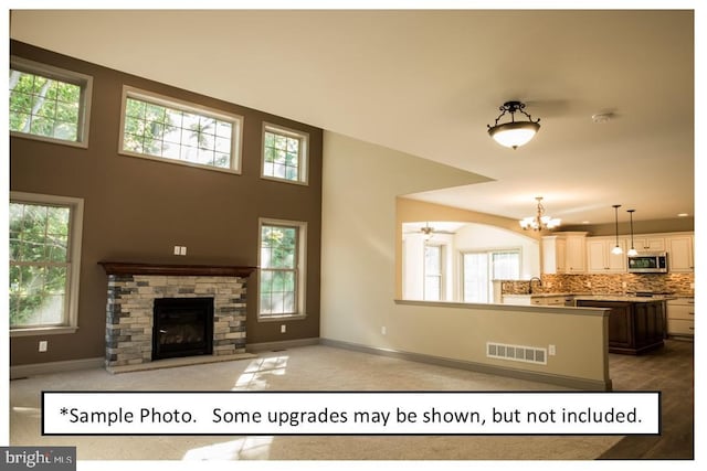 unfurnished living room with a fireplace and a chandelier