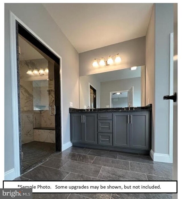 bathroom with a tile shower, tile patterned floors, and double sink vanity