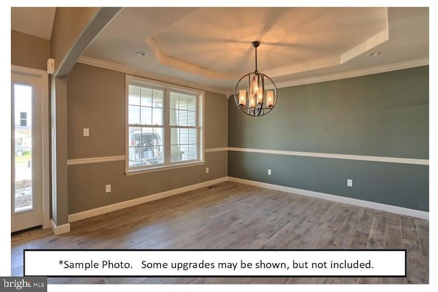 unfurnished dining area with wood-type flooring, a raised ceiling, and an inviting chandelier