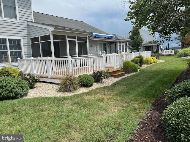 view of yard featuring a sunroom and a deck