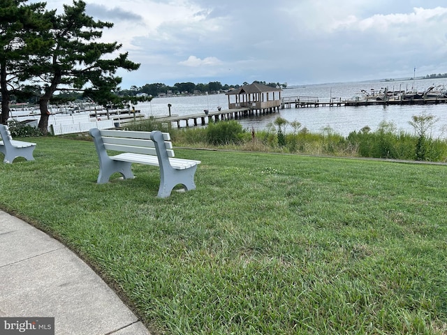 view of dock featuring a water view and a yard