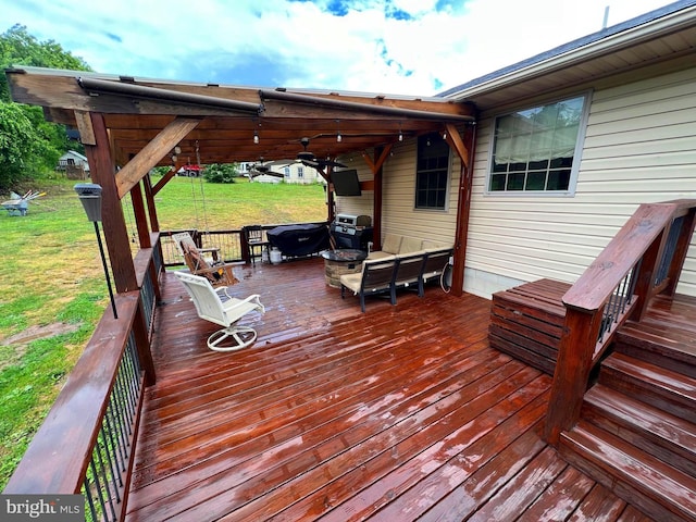 deck featuring grilling area, an outdoor hangout area, ceiling fan, and a lawn