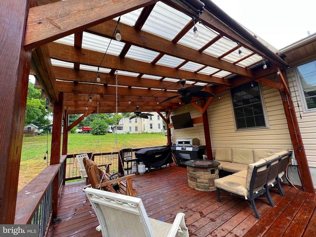 deck with a lawn, an outdoor living space with a fire pit, and ceiling fan