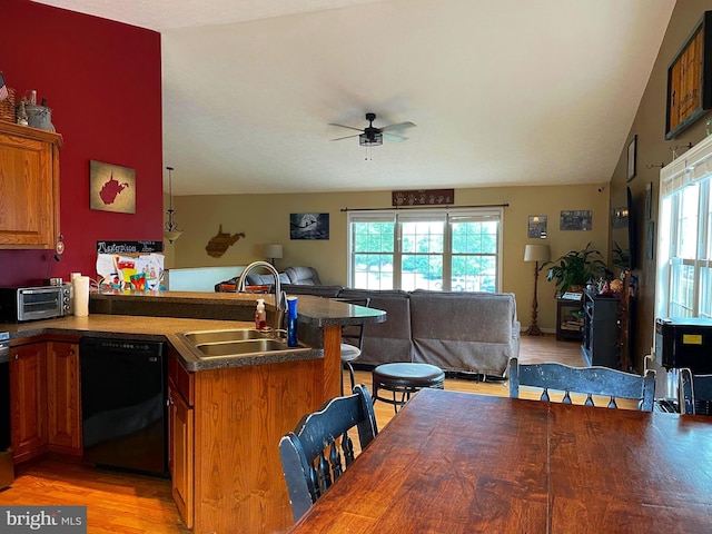 kitchen featuring sink, black dishwasher, kitchen peninsula, ceiling fan, and light hardwood / wood-style floors