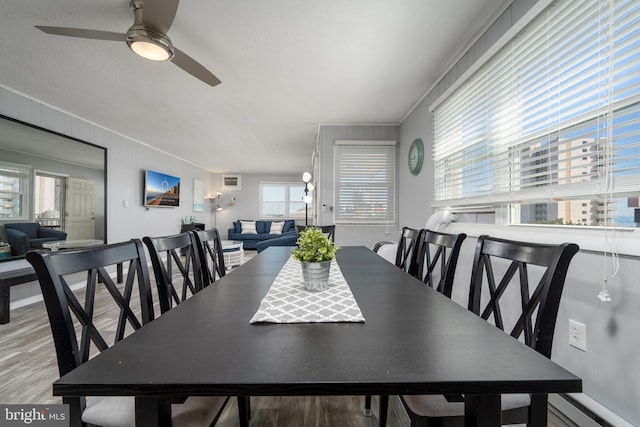 dining area with crown molding, ceiling fan, light wood-type flooring, and a baseboard heating unit