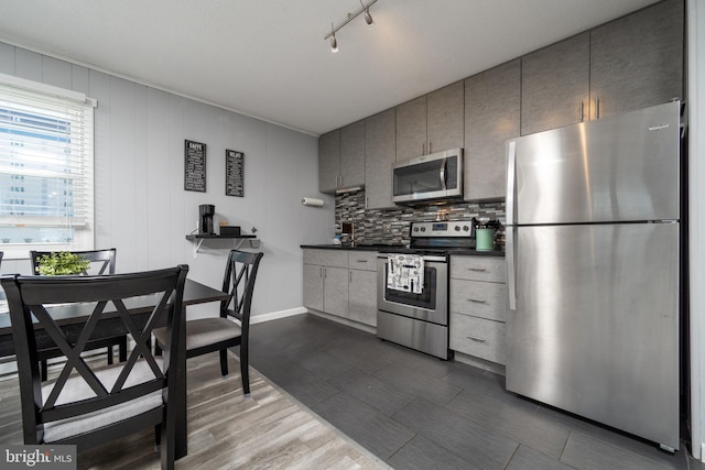 kitchen with gray cabinets, stainless steel appliances, and rail lighting