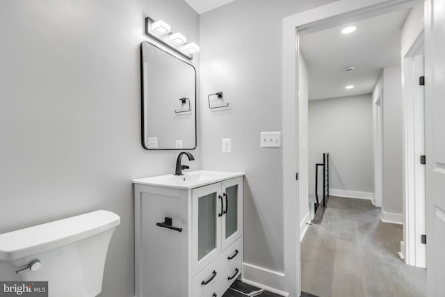 bathroom with hardwood / wood-style flooring, vanity, and toilet