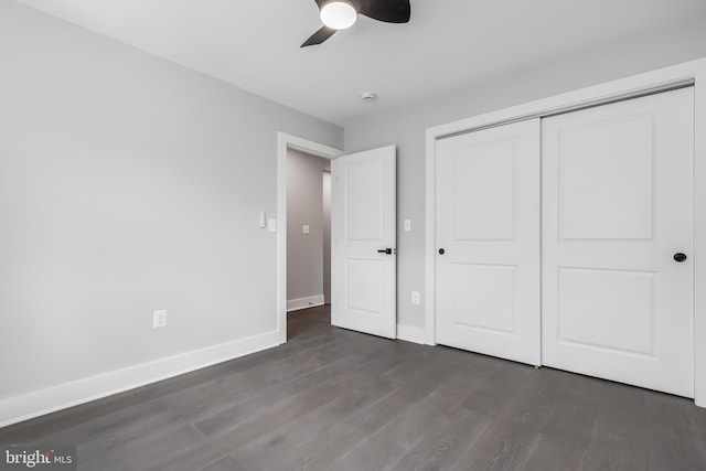 unfurnished bedroom featuring ceiling fan, a closet, and dark wood-type flooring