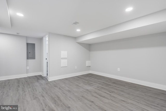 basement with hardwood / wood-style floors and electric panel