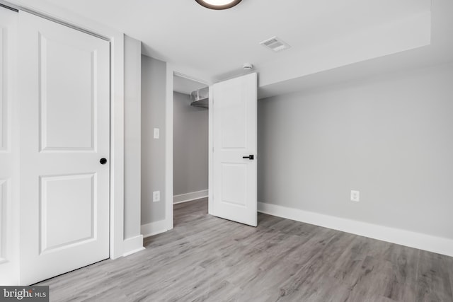 unfurnished bedroom featuring light hardwood / wood-style flooring and a closet