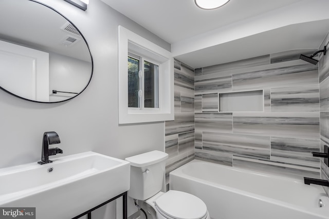 full bathroom with sink, tiled shower / bath combo, and toilet