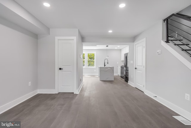 hallway with sink and wood-type flooring