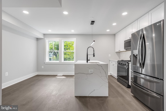 kitchen featuring stainless steel appliances, hardwood / wood-style floors, sink, light stone countertops, and hanging light fixtures