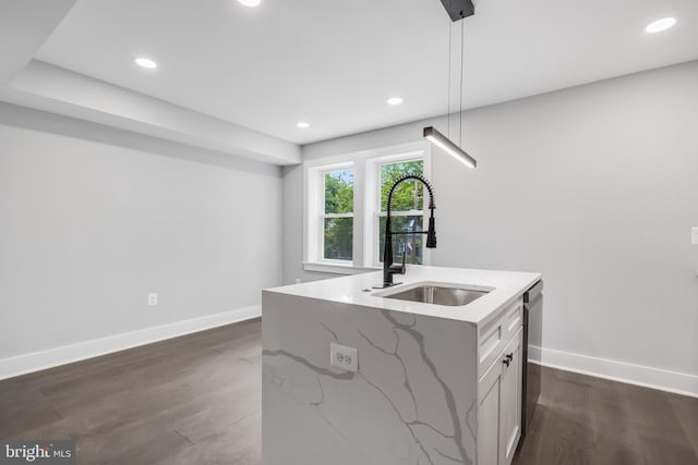 kitchen featuring white cabinetry, hanging light fixtures, light stone counters, and dark hardwood / wood-style flooring