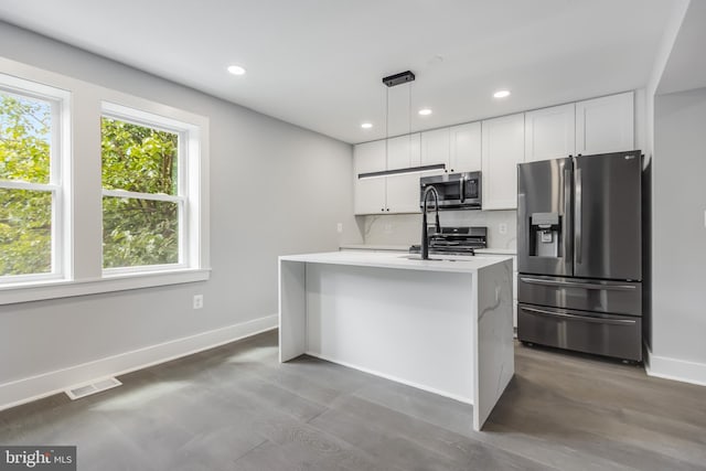 kitchen featuring decorative backsplash, pendant lighting, an island with sink, white cabinetry, and appliances with stainless steel finishes